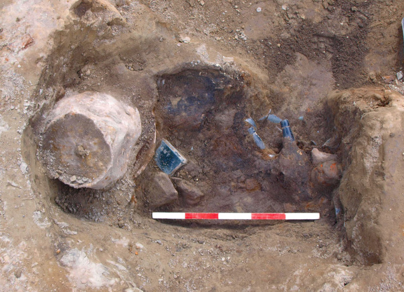 The partially excavated rubbish pit containing numerous T. B. Hall & Co sealed bottles. A couple of complete bottles are visible, sticking out of the top of the feature: one of these fell apart as it was lifted, due to the cracks already present in the glass. Image: J. Garland. 